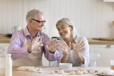 Olgun kadın ve yaşlı baba, hamuru tatile hazırlar, gülümser, birlikte hoş vakit geçirir, yemek pişirmekten ve iletişimden zevk alır, eğlenir, beyaz un avuç içleriyle oynarlar.