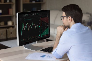 Ciddi bir adam tüccarı, analist borsa araştırması yapıyor, bilgisayar ekranına bakıyor grafikler ve grafikler halinde bilgi öğreniyor, erkek omzunda dijital verilerle ekran görüntüsü oluşturuyor. Kripto para birimi, ticaret, analitik