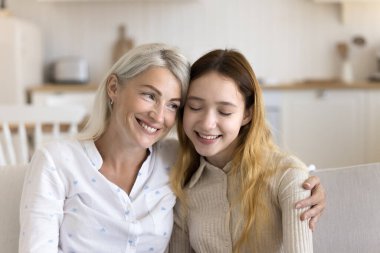 Sevgi dolu orta yaşlı bir anne, ergen kızına sarılır. Kanepeye oturur, şefkat anının tadını çıkarır. Güçlü, uyumlu ve güvenilir ilişkiler kurar.