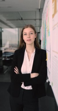 Genç iş kadını, ofis çalışanı, bayan iş adamı, modern iş yerinde resmi giyinen kurumsal antrenör, gülümse, kameraya bak, kendine güven ve profesyonellik yayıyor. Kariyer, pozisyon