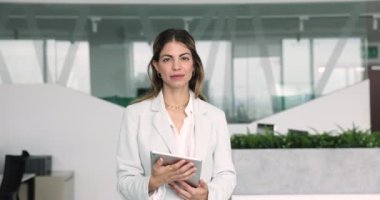 Mutlu şirket çalışanı, Latin iş kadını, iş yerinde tabletle poz veren bir çalışan. Profesyonel çalışan profili, iş akışı kullanımı kablosuz teknoloji, pazarlama bölümü başkanı
