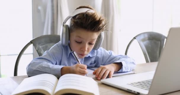 近距离男孩戴耳机听录音课程做笔记 准备作业 单独使用笔记本电脑和在线课程进行电子学习 获得新的技能 提高语言知识 Gen Z学习 视频剪辑