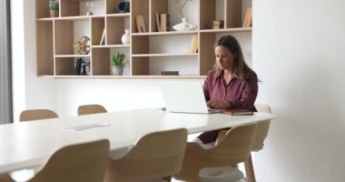 Odaklanmış iş kadını resmi yazışmalara öncülük ediyor, bilgisayarla uzaktan kumandalı e-posta yoluyla müşteriye cevap veriyor modern konferans odasında tek başına oturmak ciddi, meşgul ve düşünceli görünüyor. Teknoloji kullanılarak çalışma akışı