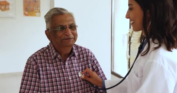 Feliz Joven Doctora Latina Examinando Paciente Mayor Escuchando Los Latidos — Vídeo de stock