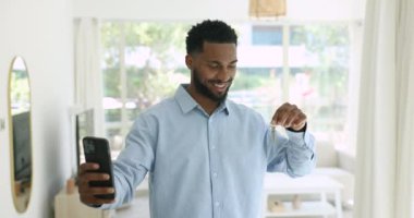 Neşeli Afrikalı adam yeni evin anahtarlarını elinde tutuyor. Video paylaşımı mutlu bir an, yurtdışında yaşayan kanal aboneleriyle ya da ailesiyle ilk emlak alımıyla ilgili haberler. Taşınma günü, kira, kira