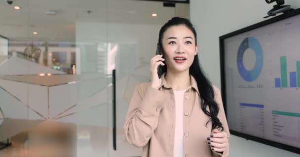 Modern Ofiste Genç Asyalı Kadını Akıllı Telefondan Konuşuyor Şirket Müşterilerine — Stok video