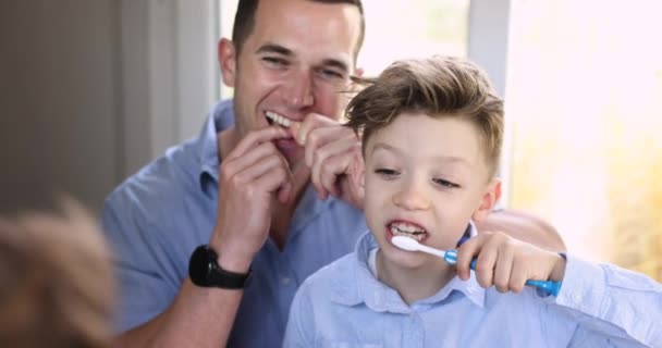 Yakın Mesafede Genç Baba Diş Ipi Kullanıyor Küçük Oğlu Dişlerini — Stok video