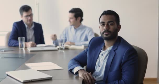 インドのオフィス従業員 銀行顧問は カメラを見ている同僚とテーブルに座ってエレガントなスーツを着ています リーダーシップ キャリア主義 成功した熟練したプロのビジネスマンの肖像 — ストック動画