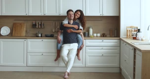 快乐的西班牙夫妇花时间在新装修的现代化厨房里 拥抱远方 享受白日梦 住房改善 向年轻家庭提供银行贷款 共同的未来 — 图库视频影像