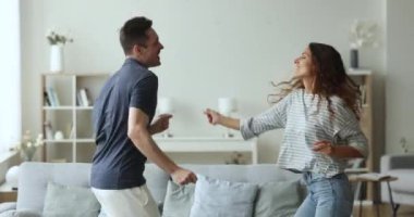 Güzel milenyum eşleri dönen, favori müzikle dans eden, mutlu görünen, tasasız görünen, hafta sonları tek başına eğlenen, modern bir dairede birlikte vakit geçiren. Aile eğlencesi, ilişkiler, hobi