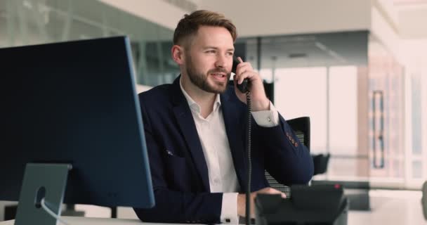 Millennial Geschäftsmann Büroangestellter Schreibtisch Mit Hält Telefonhörer Nimmt Eingehende Anrufe — Stockvideo
