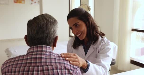 Mujer Médica Hispana Positiva Tocando Hombro Paciente Mayor Dando Pronóstico — Vídeos de Stock