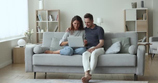Carefree 매력적인 배우자는 노트북을 사용하여 거실에서 소파에 집에서 주말을 보내고 — 비디오