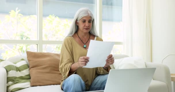 上了年纪的西班牙女人坐在沙发上 手里拿着文件 读着信 从银行那里得到贷款偿还的书面通知 高兴得大叫 庆祝养老金率的增长 经济上的成功 投资收入 — 图库视频影像
