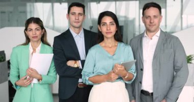 Modern şirket ofisinde kameraya poz veren personel. Resmi olarak giyinmiş Avrupalı ve Latin çalışanlar toplantı, brifing veya müzakerelere hazırlar, motive olmuş ve memnun görünüyorlar. Kariyer, meslek, iş