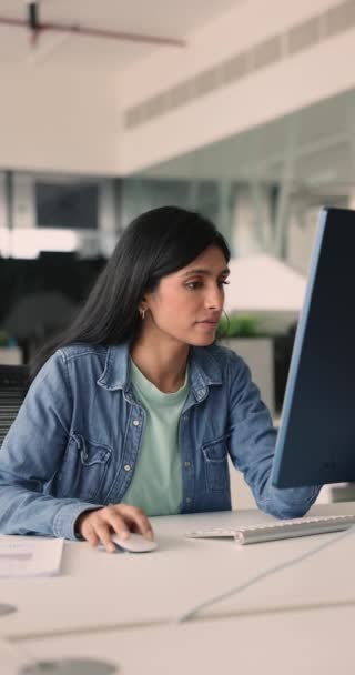 笑顔は 垂直ビューで机に座っているPcキーボードにタイプするインドのビジネス女性を満足させました 企業のオフィスの従業員は現代コンピュータを使用してレポートを準備し 研究かデータ分析を作ります — ストック動画