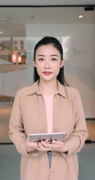 美しいアジアのビジネスマンの垂直な肖像画 デジタルタブレットに見えるカメラで職場でポーズするオフィスの従業員 プロの職業人 現代技術を使用したワークフロー ビジネスアプリ — ストック動画