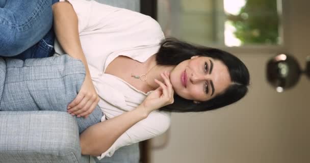 Вертикальный Взгляд Позитивной Латиноамериканской Женщины Расслабляющейся Диване Смеющаяся Одинокая Леди — стоковое видео