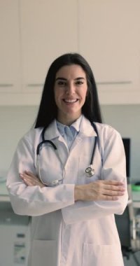 Klinikte poz veren genç Latin sağlık uzmanı, hemşire ya da hekimin profili, gülümseyin, kameraya bakın. Sağlık sigortası, teşhis ve tedavi koşulları, kurul onaylı GP portresi