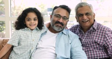 Mutlu Hintli küçük çocuğun, olgun büyükbabanın ve yaşlı büyük büyükbabanın yakın portresi. Kanepede dinlenen çok nesilli aile kameraya bak, sevgiyi hisset, korunma ve özen göster.