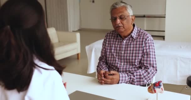 Старый Индиец Посещает Кардиологический Кабинет Разговаривает Молодой Женщиной Врачом Прислушивается — стоковое видео