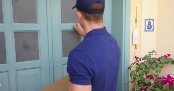 Junger Zusteller Uniform Kommt Zum Kundeneingang Klopft Tür Lächelnde Frau — Stockvideo
