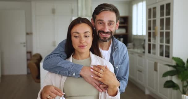 Szczęśliwa Tysiącletnia Para Małżeńska Pozująca Swoim Nowym Mieszkaniu Stojąca Przytulająca — Wideo stockowe