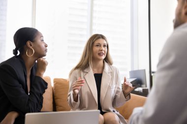 Çeşitli iş adamları iş yerinde toplanıyor, yumuşak koltukta oturuyor, konuşuyor, iş çözümlerini tartışıyor, takım çalışması stratejisi, işbirliği. İş kadını meslektaşlarına fikir veriyor