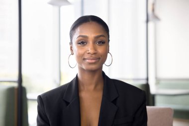 Resmi ceketli güzel Afro-Amerikan iş kadını portresi. Kadın iş adamı, girişimci, profesyonel, yönetici ortak çalışma alanında kameraya bakıyor.