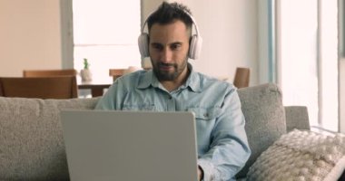İspanyol adam oturma odasındaki koltukta oturan dizüstü bilgisayarla kulaklık takıyor, baş yazışmalar yapıyor, internet sitelerinde sörf yapıyor ve favori müzikleri dinliyor. Modern teknoloji kullanımı, eğlence, eğlence