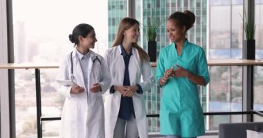 Modern klinik koridorunda yürürken, arkadaşça sohbet ederken, ara verdiğimizde görüşlerimizi paylaşırken üç çekici çok ırklı kadın sağlık görevlisi, pratisyen hekim ve hemşire, üniformalı bayan meslektaşlar konuşuyor.