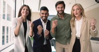 Mutlu takım üyeleri ortak başarıyı, ortak başarıyı, ofiste durmayı, yumruklarını sıkarak kameraya bakmayı, tezahürat yapmayı, gülmeyi, ödül kazanmayı veya tanınmayı, kilometre taşı veya hedef almayı kutluyorlar.