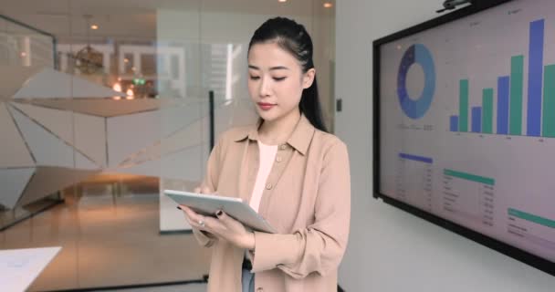 Attraktiv Asiatisk Affärskvinna Analytiker Står Kontoret Nära Displayen Visar Försäljningsstatistik — Stockvideo