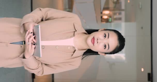 美しいアジアのビジネスマンの垂直な肖像画 デジタルタブレットに見えるカメラで職場でポーズするオフィスの従業員 プロの職業人 現代技術を使用したワークフロー ビジネスアプリ — ストック動画