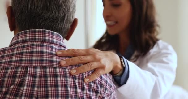 Opiekuńcza Młoda Latynoska Lekarka Przekazująca Starszemu Pacjentowi Optymistyczne Wieści Dotykająca — Wideo stockowe