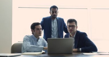 Pazarlama stratejisi üzerinde düşünen, konferans odasında dizüstü bilgisayar kullanarak birlikte çalışan üç dost canlısı çok ırklı iş arkadaşı. Çalışma akışı, teknoloji, yeni uygulama, program kullanımı