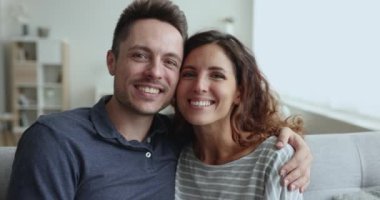 Genç ve sevecen İspanyol eşlerin yakın portresi kameraya bakıp gülümseyen, aile fotoğrafı için poz veren. Romantizm, ilişkiler ve harmonik mutlu evlilik, çift video çağrı etkinliğine katılıyor