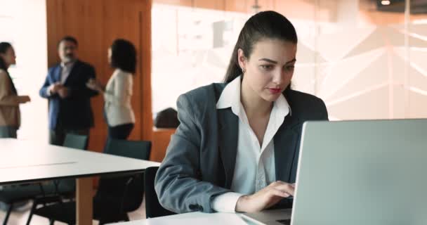 Dizüstü Bilgisayarla Çalışan Odaklanmış Kadını Arka Planda Arkadaşlarıyla Şirket Ofisinde — Stok video