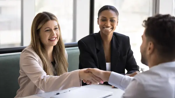 ポジティブな満足のいく多民族ビジネスパートナーは 会議で握手 終わりの会話 合意を得る ハッピーな顧客がコンサルタントに握手をする ストック画像