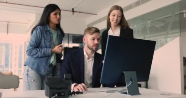 Çeşitli ofis çalışanları PC ekranına bakar, konuşur, ortak proje üzerinde işbirliği yapar, stratejiyi tartışır, güncellemeleri paylaşır, verileri analiz eder, yaratıcı fikirleri beyin fırtınası yapar, görevleri koordine eder, takım çalışması yapar.