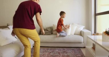 Aktif baba ve küçük 7 'nin oğlu eğleniyor, oturma odasında birlikte oynuyorlar, arayı kapatıyorlar, koşuyorlar ve yere yığılıyorlar, rahat kanepeye atlıyorlar, boş zamanların tadını çıkarıyorlar. Evde çocukların oynadığı oyunlar