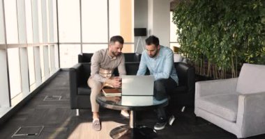 Genç takım arkadaşları ofiste ortak görevi tartıştılar, dizüstü bilgisayar paylaşımı çözümü kullandılar, strateji planladılar, fikirleri değerlendirdiler, modern ofis lobisinde kurulmuş projeyi hazırladılar. Takım çalışması, koçluk, danışmanlık, yeni uygulama