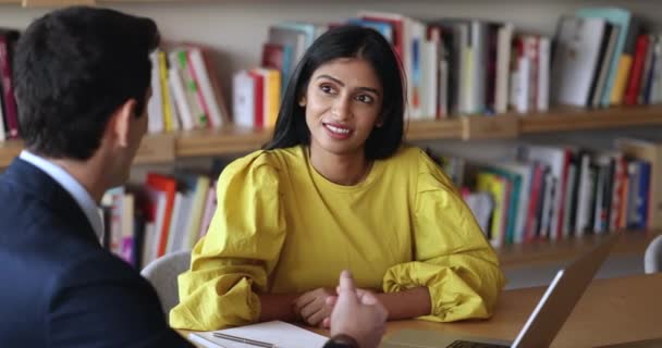 自信を持って肯定的な若いインドの女性リーダーは男性のパートナーにコンピュータプレゼンテーションを示し 一緒にラップトップを使用し 新しいプロジェクトの詳細を議論し 成功したパートナーは会議でアイデアを共有します ロイヤリティフリーのストック動画