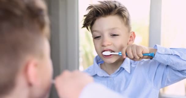 Feche Menino Bonito Olhando Espelho Fazendo Rotina Matinal Escovando Dentes — Vídeo de Stock