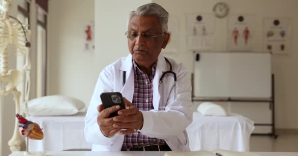 Alter Indischer Arzt Der Sein Mobiltelefon Für Die Internetkommunikation Benutzt — Stockvideo