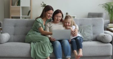 Pozitif odaklı çocuk, dizüstü bilgisayar kullanan anne ve büyükanne, evde birlikte internet teknolojisi, bilgisayardaki sosyal medyayı taramak, ekom uygulaması ile online alışveriş, servis, içeriği izlemek