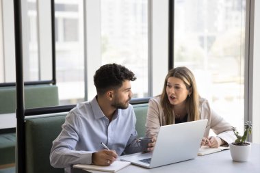 Birkaç iş arkadaşı laptopta konuşuyor, birlikte çalıştığı kafede masada oturuyor, iş ödevlerini, proje planını, notları tartışıyor, yaratıcı fikirler üzerine beyin fırtınası yapıyor. Danışman eğitim çalışanı
