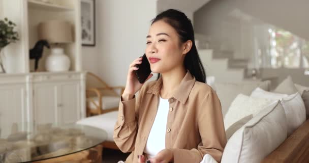 Hübsche Asiatin Führt Hause Angenehme Gespräche Auf Dem Smartphone Spricht — Stockvideo