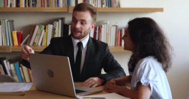 Genç kızıl iş adamı dizüstü bilgisayarda sunum yapan şirket müşterisine iş teklifinde bulunuyor, anlaşma detaylarını kadın müşteriye açıklıyor, tokalaşıyor, başarılı bir müzakere toplantısı yapıyor.