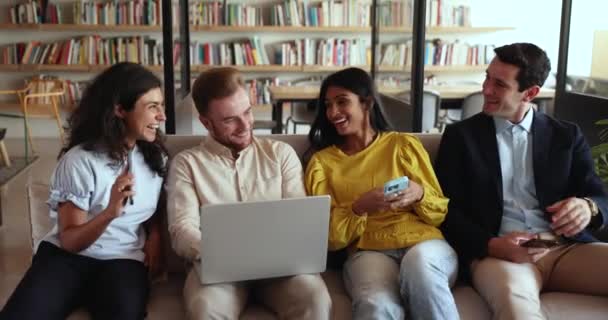 Four Happy Multiethnic Office Employees Coworkers Using Devices Sit Sofa — Stock Video